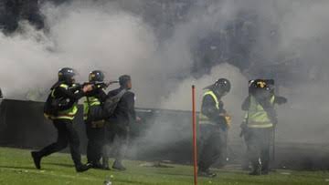 Polisi tembakkan gas air mata ke tribun penonton di Stadion Kanjuruhan yang berujung tewasnya ratusan massa Aremania termasuk anak-anak.(foto: int)